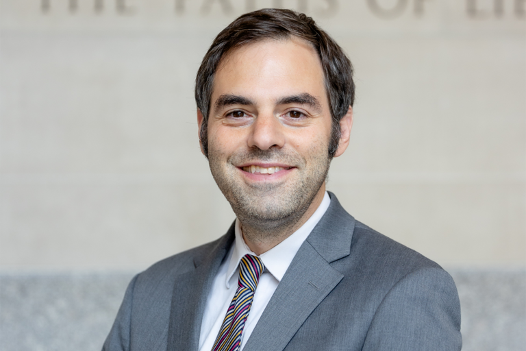 Michael Kugelman smiling in grey suit